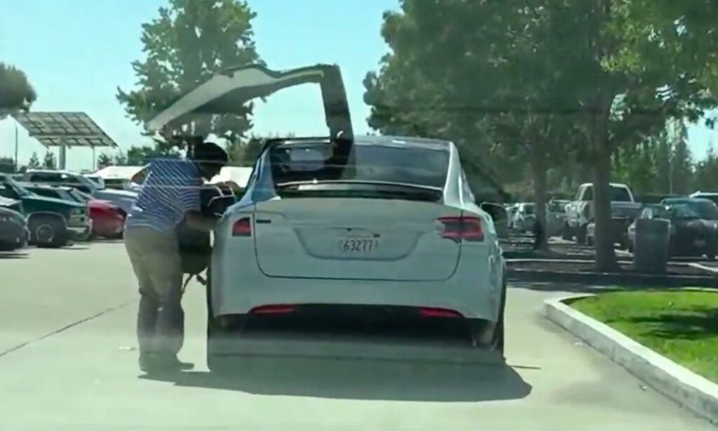 En man öppnar dörren till en bil. (AI text)