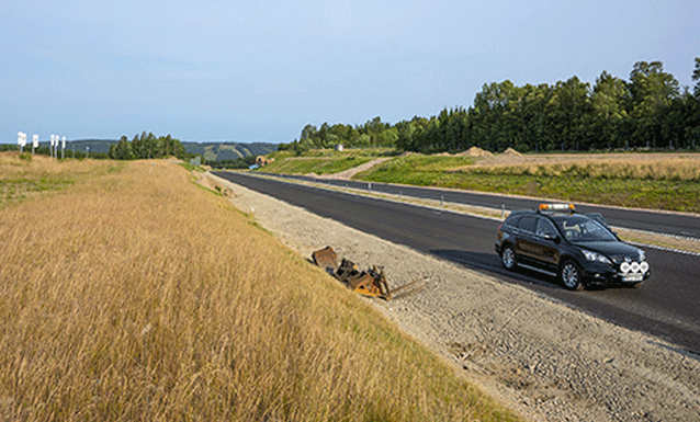 En bil kör ner en väg. (AI text)