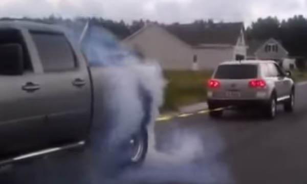 En lastbil kör nerför vägen med rök som kommer ut ifrån den. (AI text)