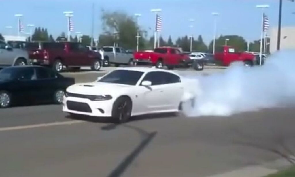 En vit Dodge Charger SRT kör ut på gatan med stor prägel. (AI text)