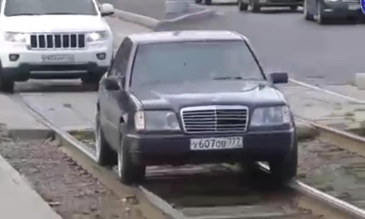 En bil kör ner längs en järnvägsspår. (AI text)