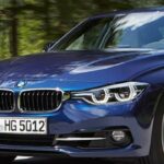 BMW 3-serien sedan kör längs en landsväg. (AI text)
