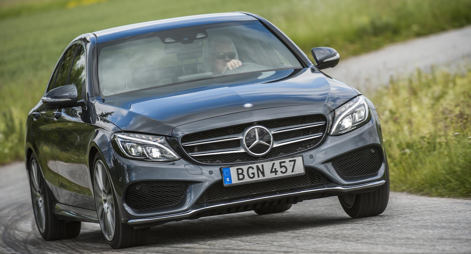 Mercedes-Benz C-klass sedan kör längs en landsväg. (AI text)