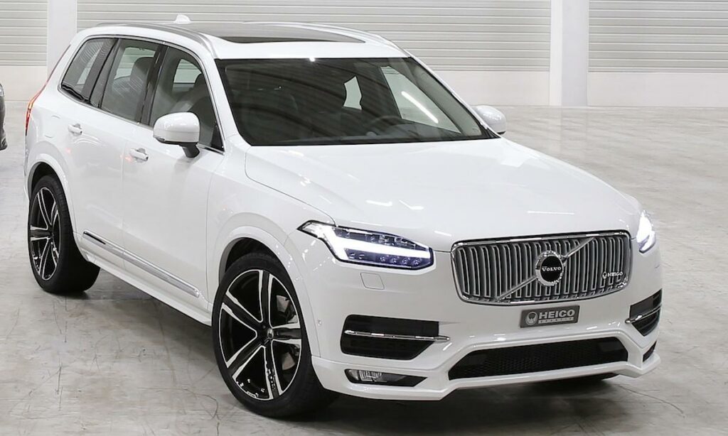 En vit Volvo XC90 står parkerad i en garage. (AI text)