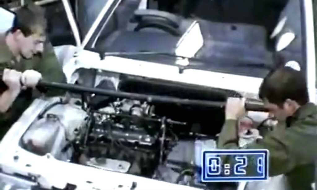 Två män arbetar på en bilmotor. (AI text)