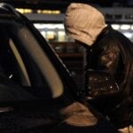 En man står parkerad framför en bil. (AI text)