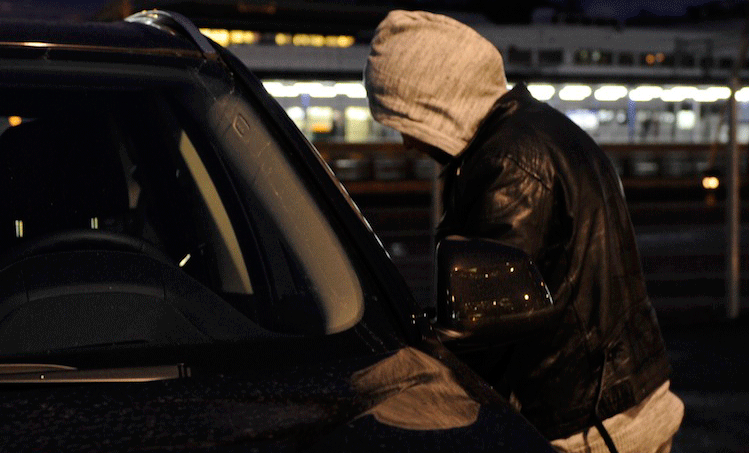 En man står parkerad framför en bil. (AI text)