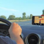 En man kör en bil med en GPS-enhet. (AI text)