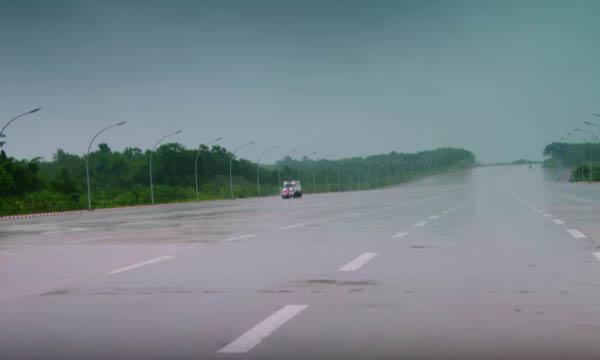 En bil kör på en blöt väg under regnet. (AI text)