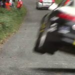 En rallybil kör nedför en backe. (AI text)
