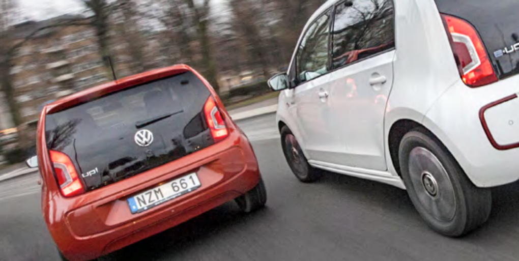 Två Volkswagen-bilar kör nerför gatan. (AI text)