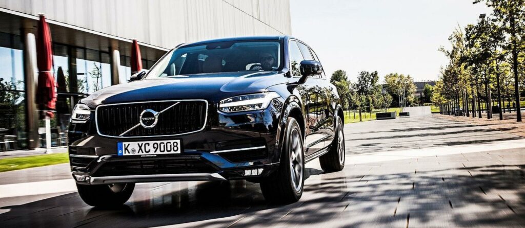 En Volvo XC90 kör ner en gata. (AI text)
