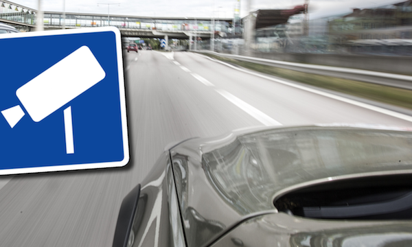 En bil kör nerför en väg med en skylt. (AI text)