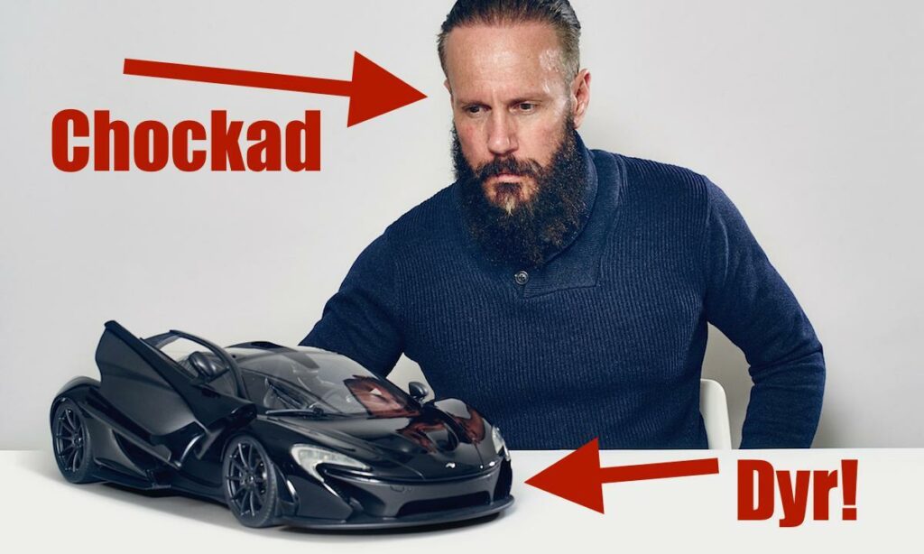 En man poserar med en leksaksbil. (AI text)