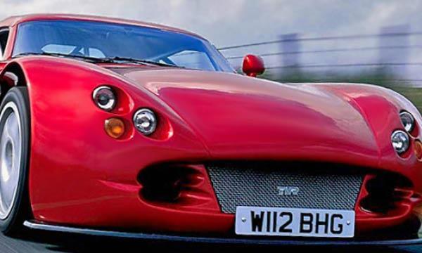 En röd sportbil kör nerför en väg. (AI text)