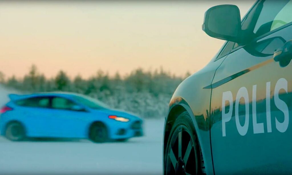En polisbil kör på en snöig väg. (AI text)