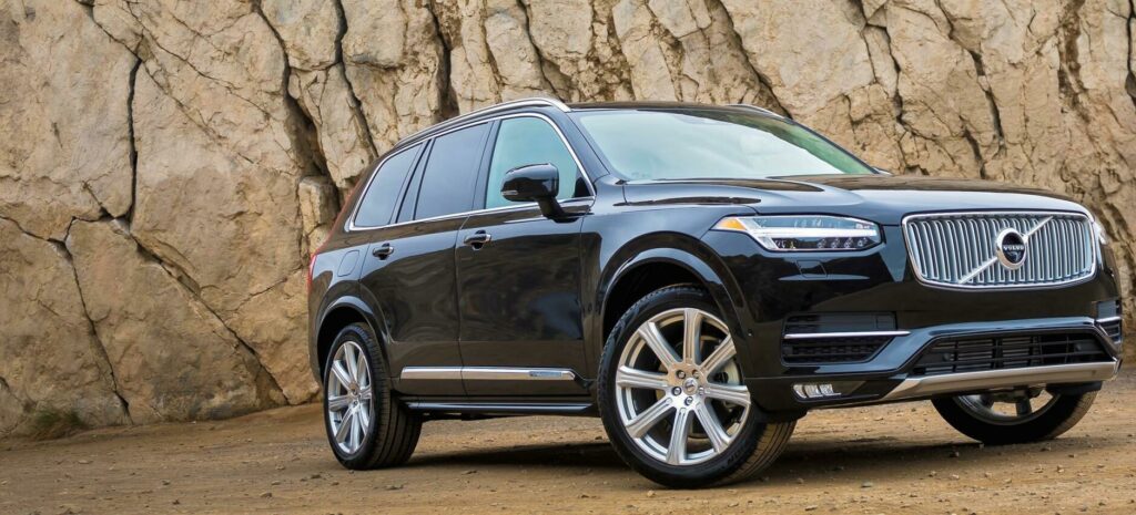 Volvo XC90-terrängbilen parkerad framför en bergig bergskedja. (AI text)