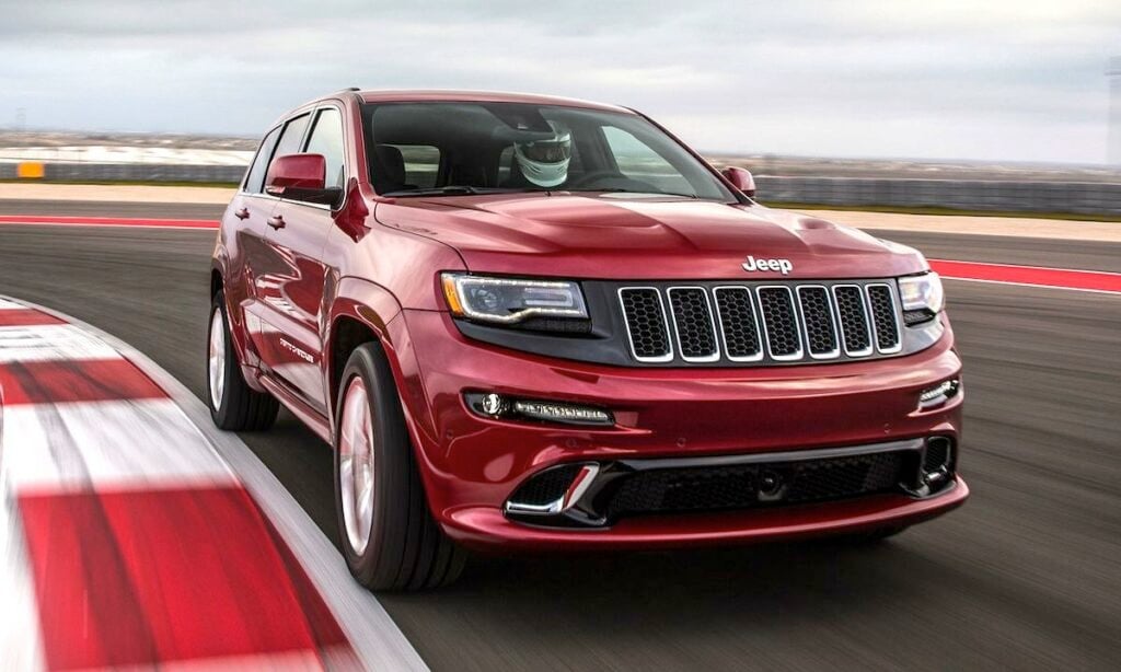 En röd Jeep Grand Cherokee kör på en racerbana. (AI text)