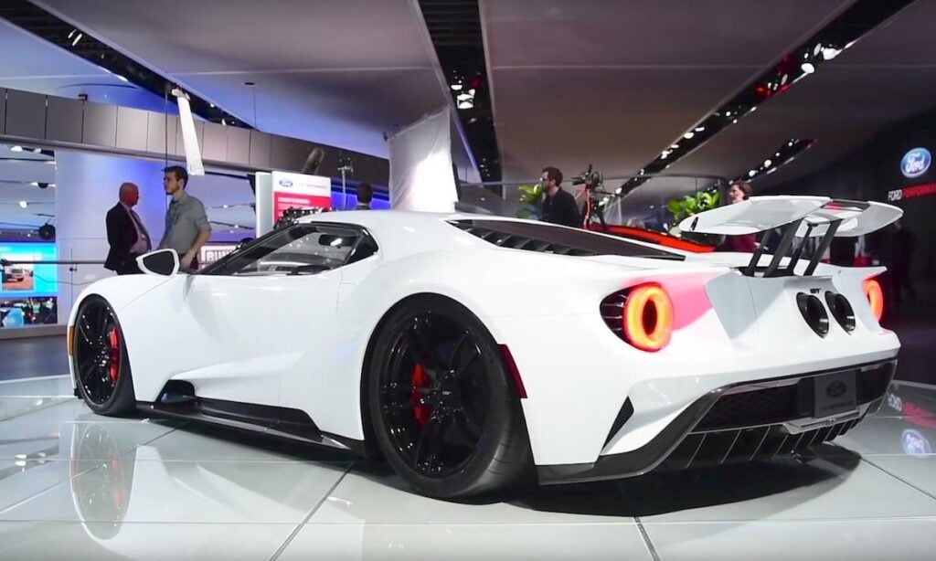 En vit sportbil visas upp på Detroit Auto Show. (AI text)