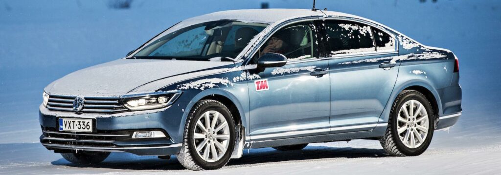 En Volkswagen Passat kör på en snöig väg. (AI text)