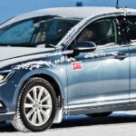 En Volkswagen Passat kör på en snöig väg. (AI text)