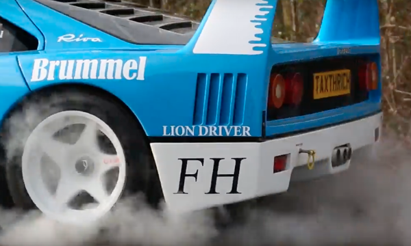 En blå och vit rallybil kör längs en väg. (AI text)