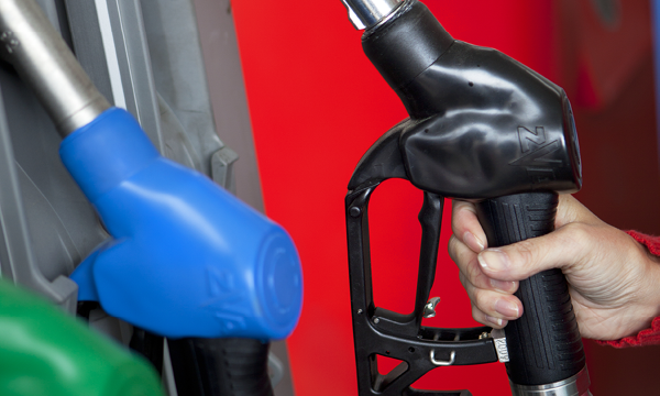 En man tankar sin bil med bränsle på en bensinstation. (AI text)