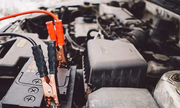 En bil med en batteri och en hoppkabel. (AI text)