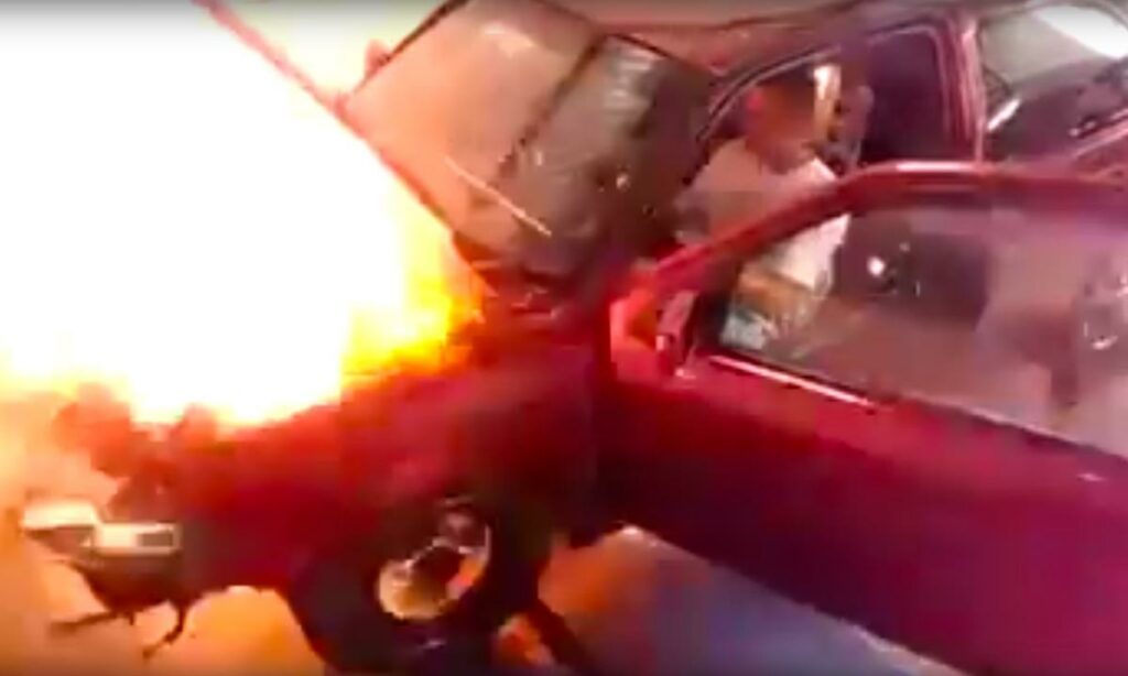 En bil brinner i en garage. (AI text)