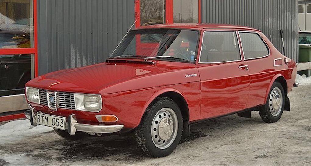 En röd bil parkerad framför ett byggnad. (AI text)