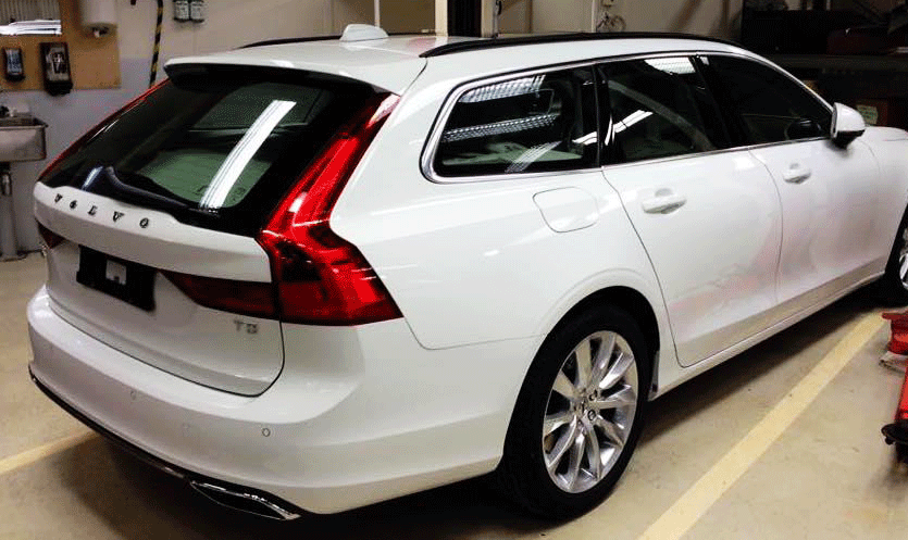 En vit Volvo V60 bagagevagn i en garage. (AI text)