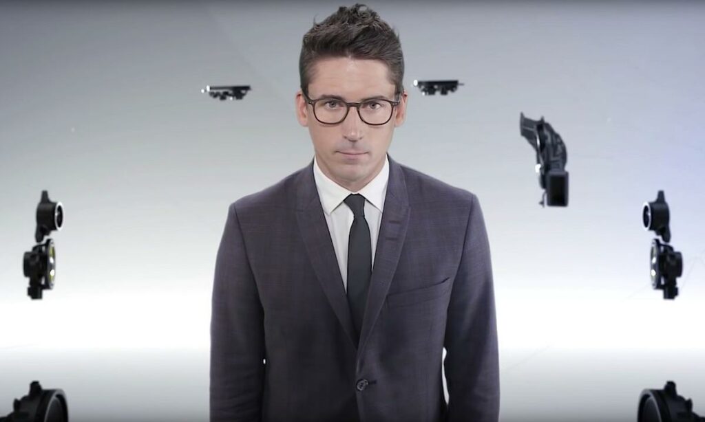 En man i kostym och slips står framför en bil. (AI text)