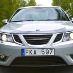 En silverfärgad bil kör nedför en landsväg. (AI text)