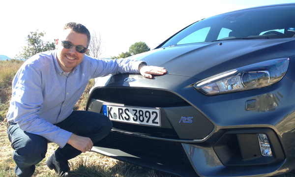 En man kneglar bredvid en Ford Focus RS. (AI text)