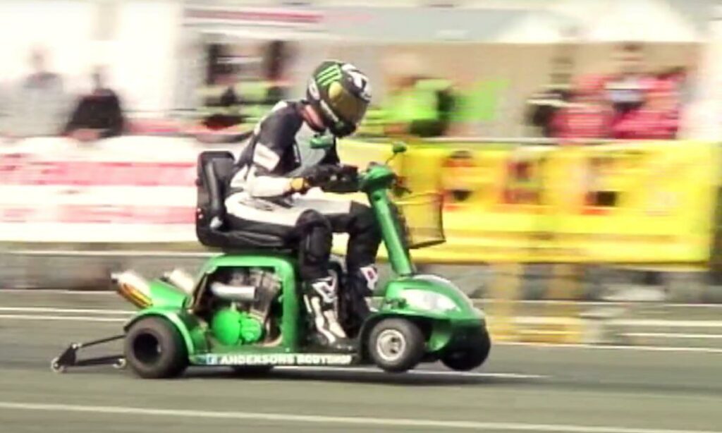 En person cyklar på en scootare på en racerbana. (AI text)