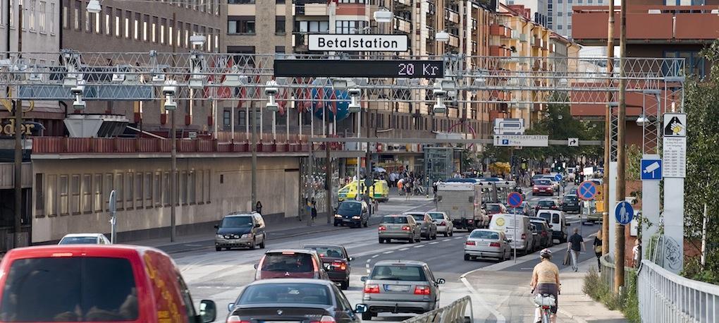 En stadsgata med bilar och människor. (AI text)