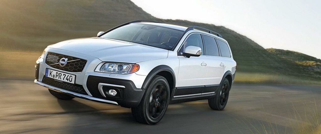 En vit Volvo XC90 SUV kör nerför en landsväg. (AI text)