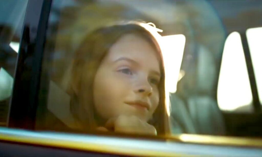 En tjej sitter i bilen. (AI text)