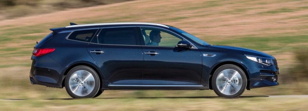 En svart Kia Optima kör nedför en landsväg. (AI text)