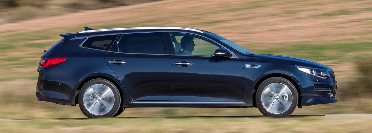 En svart Kia Optima kör nedför en landsväg. (AI text)