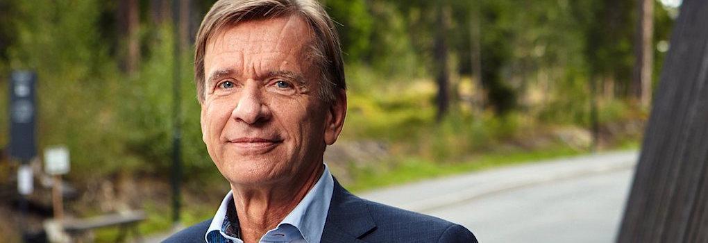 En man i kostym står bredvid en bil. (AI text)