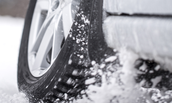 En bil kör på en snöig väg. (AI text)