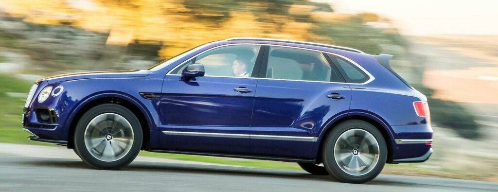 En blå Bentley SUV kör nerför en landsväg. (AI text)