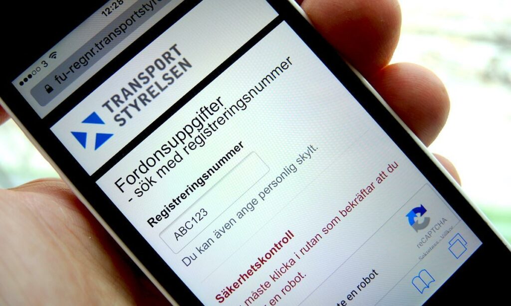 En person håller en smartphone med transportsync-websiten visas på den. (AI text)