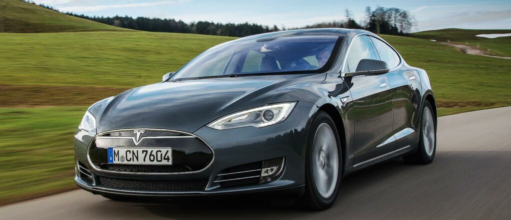 En Tesla Model S kör nerför en landsväg. (AI text)
