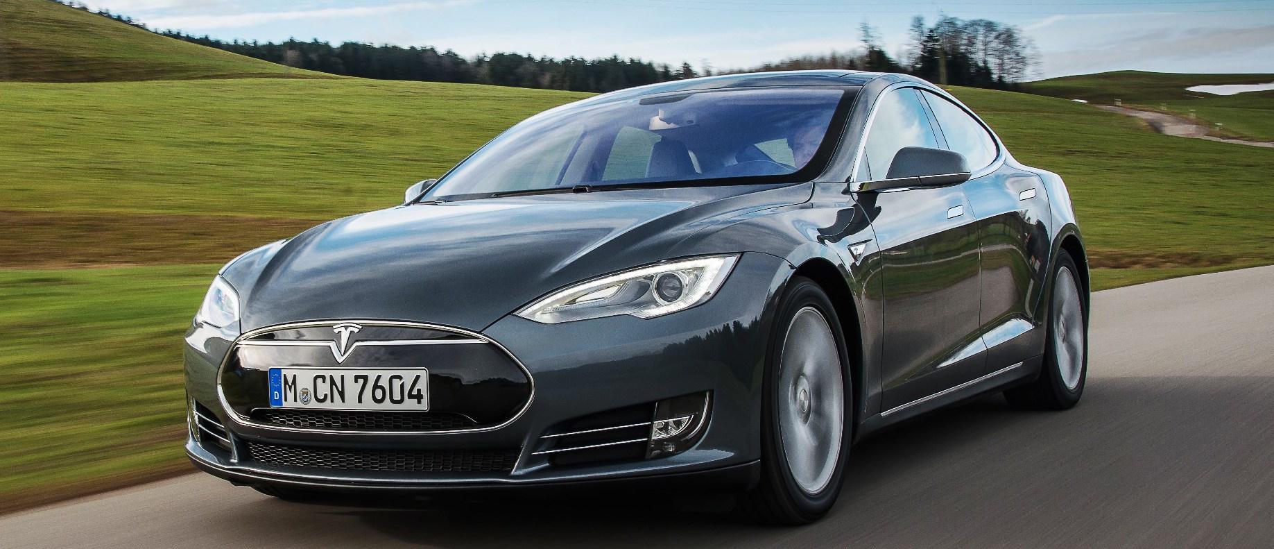 En Tesla Model S kör nerför en landsväg. (AI text)