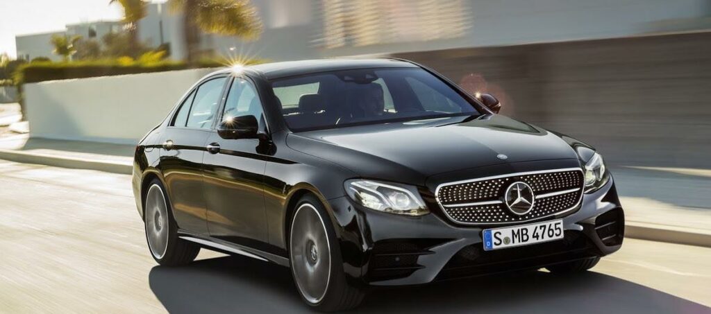 Mercedes-Benz E-sedankar kör längs vägen. (AI text)