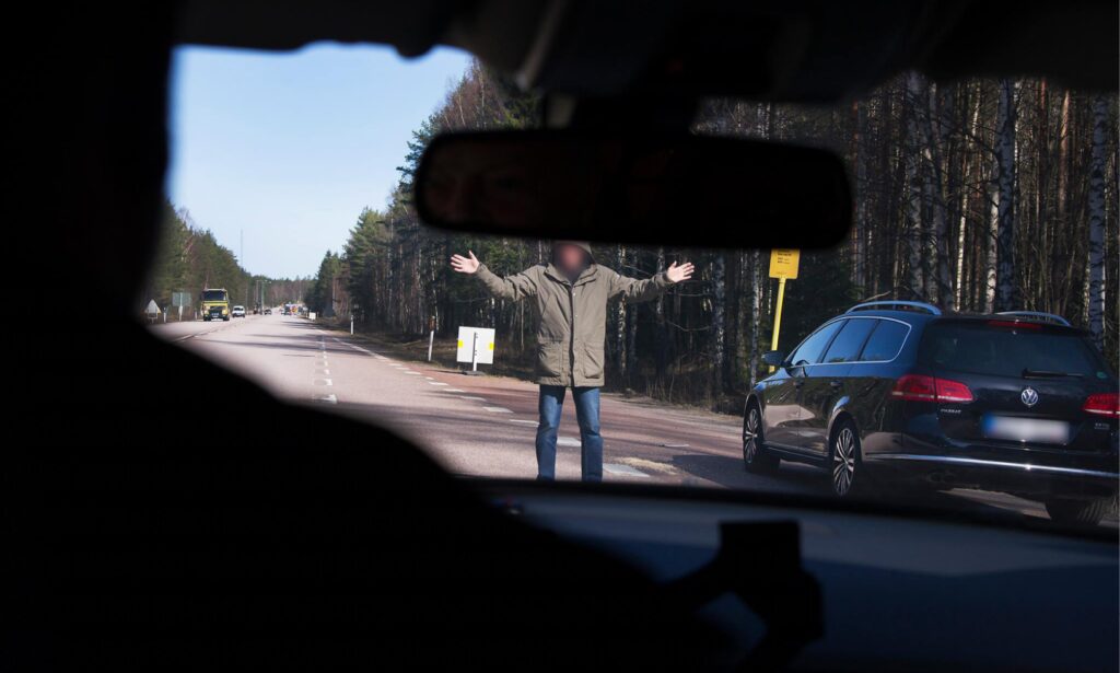 En man står i bilens fönster. (AI text)