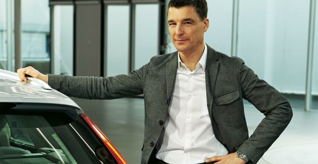 En man står bredvid en bil. (AI text)