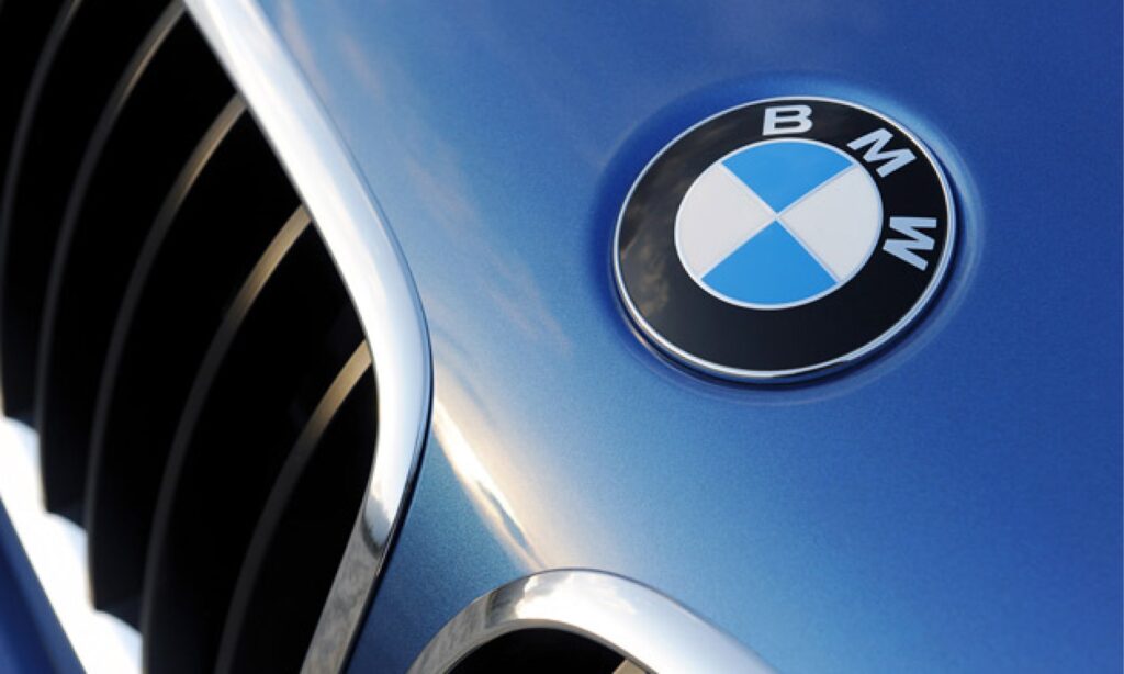 BMW-logotyp på ratten av en blå bil (AI text)